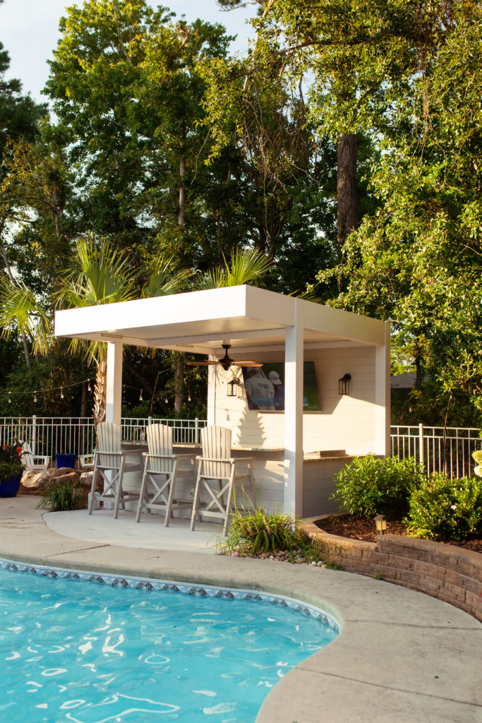 outdoor kitchen bar with white fixed roof pergola