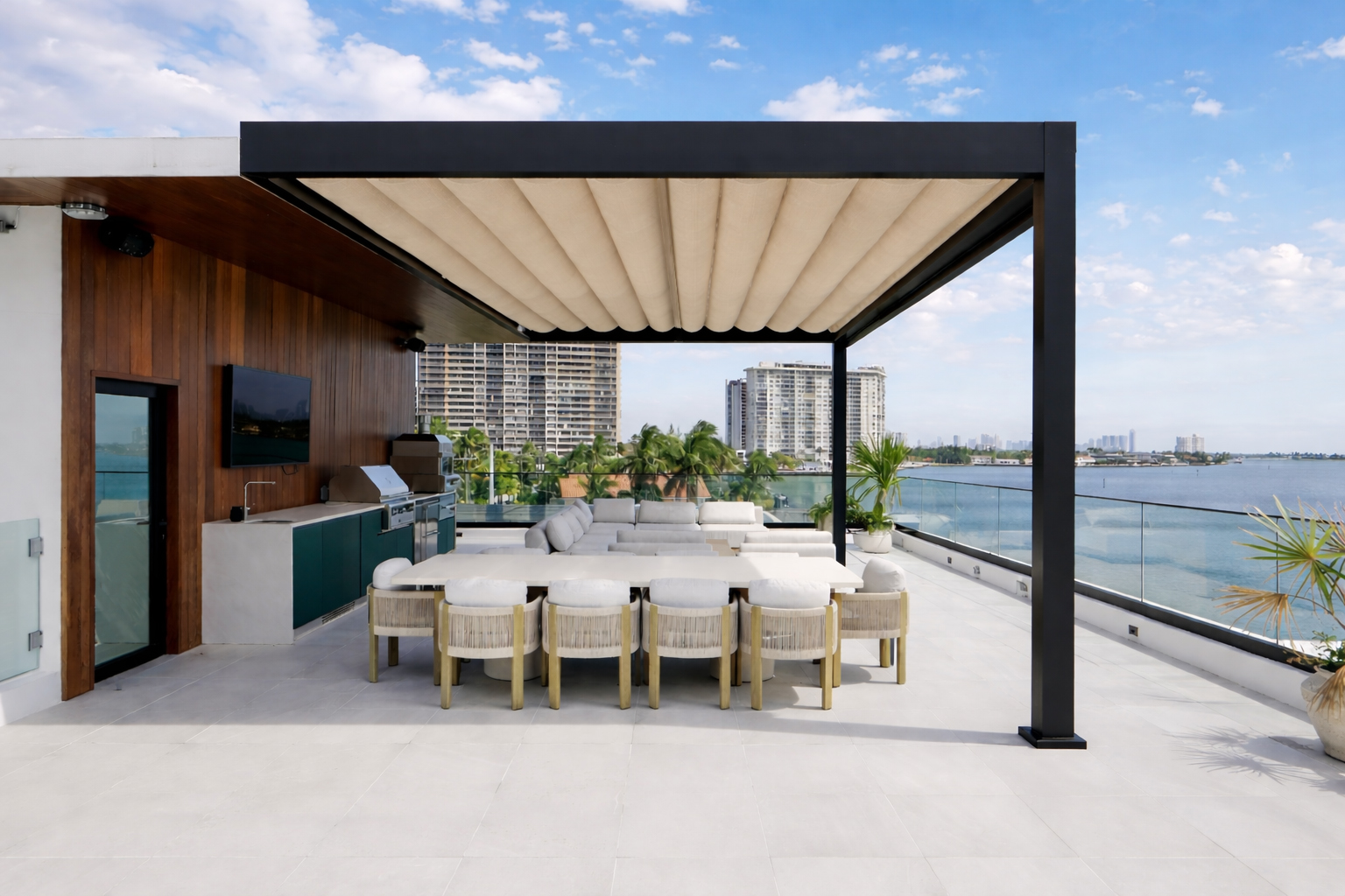 Black R-WEAVE retractable pergola shading an outdoor dining table on a waterfront terrace.